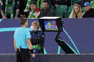 Georgi Kabakov, arbitre bulgare, consulte l'assistance vidéo en bord de terrain lors du match entre le VfL Wolfsburg et le FC Séville le 29 septembre 2021.
