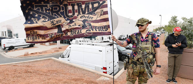 Un partisan de Donald Trump exhibe un drapeau et une arme automatique le 7 fevrier 2020 a Las Vegas.
