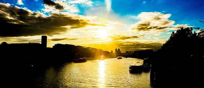 Le Soleil se couche sur la Seine a Paris le 21 juin 2019 a l'issue du jour le plus long de l'annee, correspondant au soltice d'ete.
