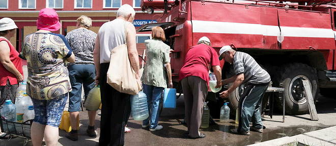 Des civils ukrainiens font la queue pour obtenir de l'eau. 
