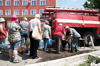 Des civils ukrainiens font la queue pour obtenir de l'eau. 
