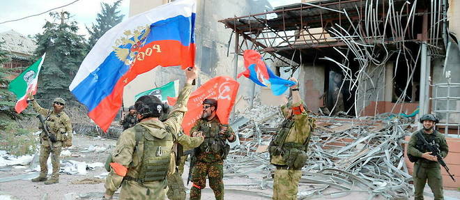 Forces tchétchènes et séparatistes devant le principal bâtiment administratif de Lyssytchansk, dans la région de Louhansk.  
