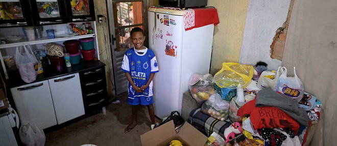 Miguel Barros dans sa maison de Santa Luzia avec les dons de nourriture recus apres avoir appele la police a l'aide.
