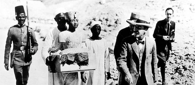 Exhumation des objets funeraires du tombeau de Toutankhamon dans la vallee des Rois. Carter (avec une canne) lors du transport des << mannequins >> de Toutankhamon.
