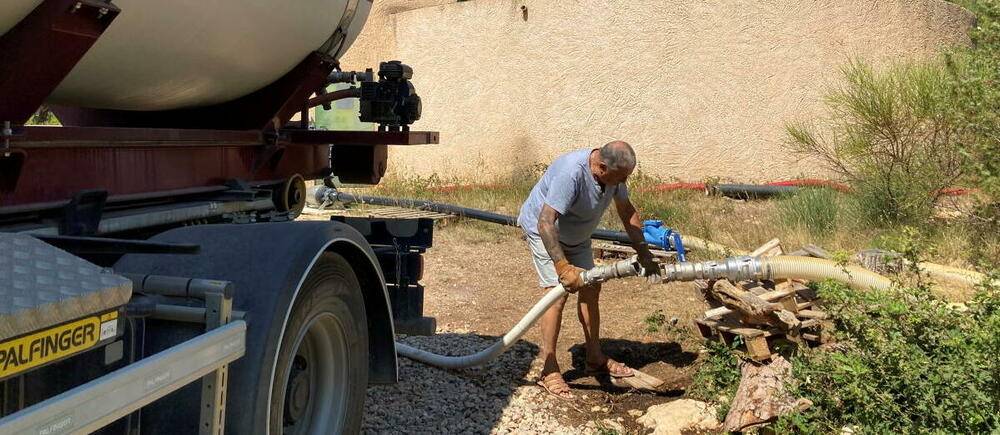 Tous les jours, Daniel, 77 ans, fait des allers-retours en camion-citerne pour remplir le reservoir d&#039;eau potable dont la source s&#039;est tarie.

