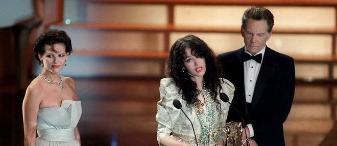 Isabelle Adjani, entouree de Claudia Cardinale et de Jean-Pierre Aumont, lorsqu'elle cite Salman Rushdie sur la scene des Cesar, le 4 mars 1989 a Paris.
