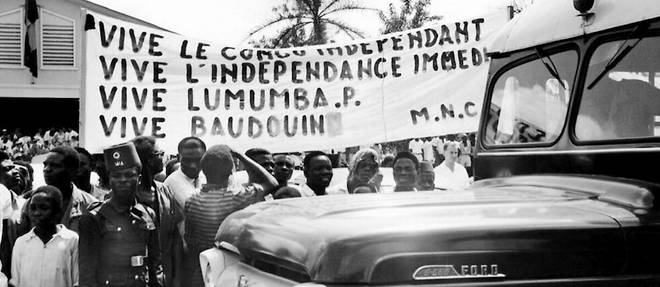 Photo publiee le 18 decembre 1960 a Stanleyville (aujourd'hui Kisangani) de Congolais tenant une banderole revendiquant l'independance du Congo et soutenant le dirigeant Patrice Lumumba, alors que le roi Baudouin de Belgique visite l'ancienne colonie du Congo belge (Congo Belge), aujourd'hui appelee Republique democratique du Congo (RDC). Le Congo belge est devenu independant le 30 juin 1960. 
