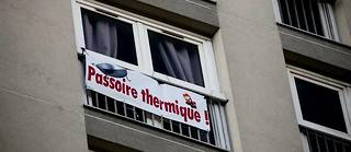 Des banderoles accrochées aux fenêtres avec le message « Passoire thermique » dénonce un problème d'isolation thermique dans un logement HLM de la ville de Paris.
