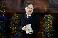 Italian scholar and physicist, co-winner of the 2021 Nobel Physics Prize, Giorgio Parisi displays his medal after he received the 2021 Nobel Prize medal and diploma from Swedish Ambassador in Rome during a ceremony on December 6, 2021 in the Aula Magna room at the Sapienza University of Rome. - US-Japanese scientist Syukuro Manabe, Klaus Hasselmann of Germany and Giorgio Parisi of Italy on October 5, 2021 won the Nobel Physics Prize for climate models and the understanding of physical systems. (Photo by Filippo MONTEFORTE / AFP)