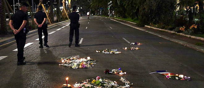 Des agents de police sur la Promenade des Anglais, a cote de fleurs rendant hommage aux victimes le 17 juillet 2016.
