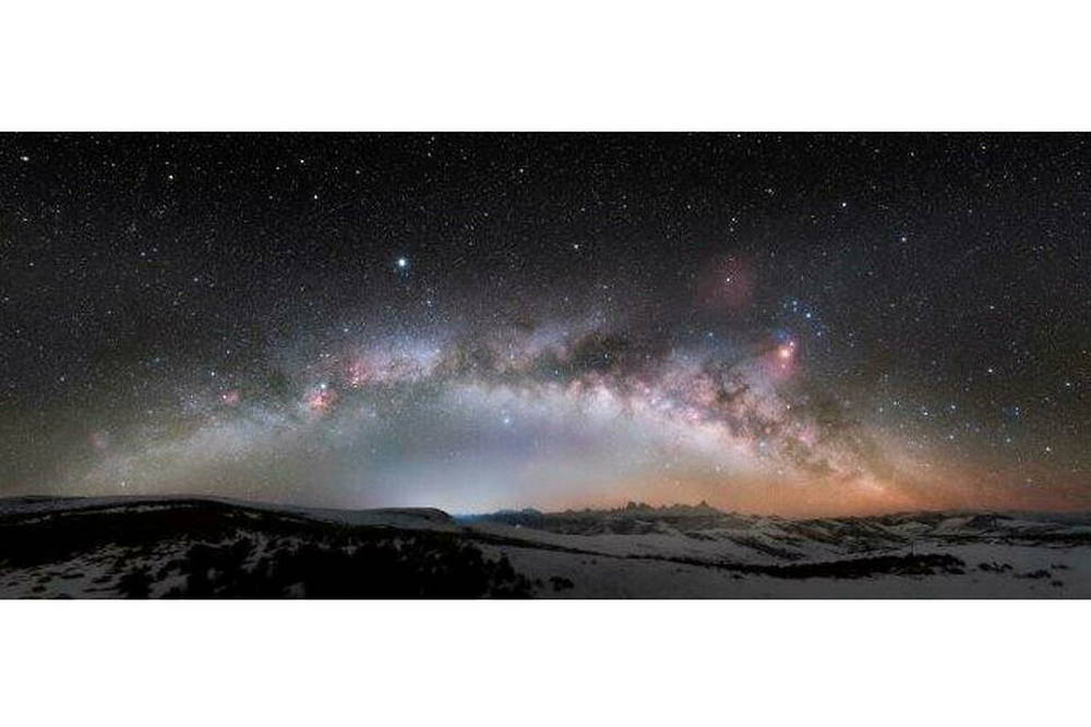 The Milky Way bridge across big snowy mountains