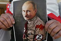 Un manifestant polonais tient un portrait du président russe Vladimir Poutine habilé d'un uniforme nazi, lors d'un rassemblement en soutien à l'Ukraine et la Biélorussie, le 4 septembre 2022 à Gdansk.

