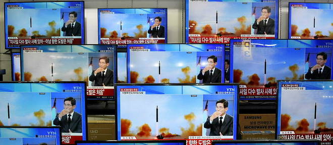 Des ecrans de television montrent un reportage sur l'un des derniers tirs de missile nord-coreen, avec des images d'un test de missile nord-coreen, le 3 novembre 2022. 

