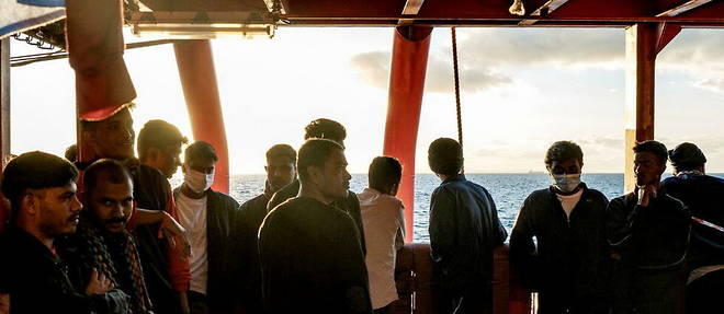 Des migrants a bord du navire << Ocean Viking >>  regardent l'horizon, au large du golfe de Catane.
