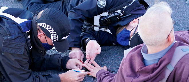 Mobilises. Deux policiers decollent la main d'un activiste, dans la banlieue de Londres, le 2 novembre.
