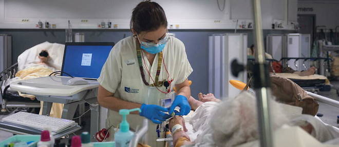 Une infirmiere preleve du sang sur une personne agee aux urgences.
