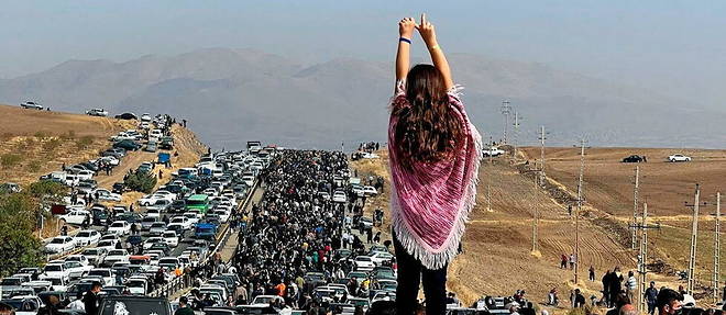 Une image, publiee sur Twitter le 26 octobre 2022, d'une femme non devoilee debout sur un vehicule alors que des milliers de personnes se dirigent vers le cimetiere d'Aichi a Saqqez, la ville natale de la jeune Mahsa Amini, dans la province iranienne occidentale du Kurdistan, pour marquer les 40 jours depuis sa mort.
