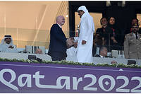 L'émir du Qatar, le cheikh Tamim bin Hamad al-Thani, serrant la main du président de la Fifa, Gianni Infantino, avant le match de football du groupe A de la Coupe du monde entre le Qatar et l'Équateur au stade Al-Bayt d'Al Khor, au nord de Doha, le 20 novembre.
