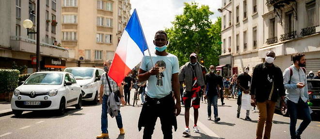 A Paris, le 20 juin 2020, une personne tient un drapeau francais lors d'une manifestation pour la regularisation des sans-papiers en France. 
