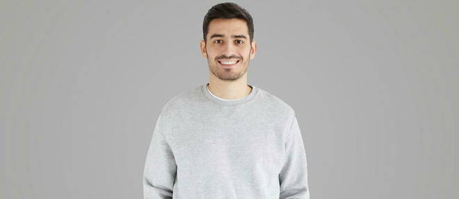 Young man in oversized sweatshirt, isolated on gray background