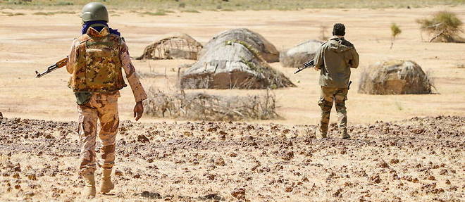 Deux soldtas des Forces armees maliennes (FAMa) du G5 Sahel avancent vers un village nomade pour verifier la presence de djihadistes a Gourma malien, en janvier 2021.
