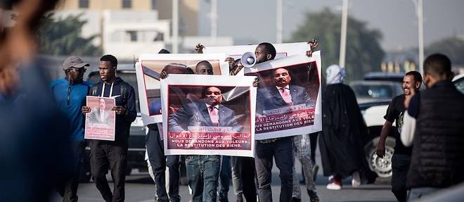 Des manifestants brandissent des affiches representant l'ancien president mauritanien, Mohamed Ould Abdel Aziz, avant son proces a Nouakchott le 25 janvier 2023.

