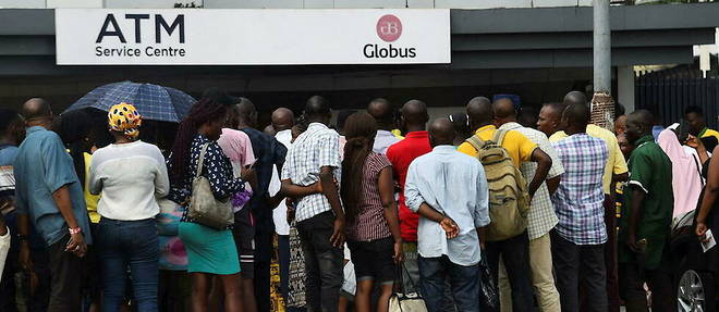 Des dizaines de personnes font la queue pour retirer de nouveaux billets en naira depuis un guichet automatique a Lagos le 1er fevrier 2023. En octobre 2022, le gouvernement nigerian a annonce changer les billets (y compris leur couleur), et a decide que les anciens billets ne seraient plus valides au 31 janvier.
