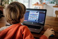 Un enfant de 9 ans regarde un tutoriel video sur Youtube sur un ordinateur pour l aider a jouer a Minecraft. Photo d'illustration.
