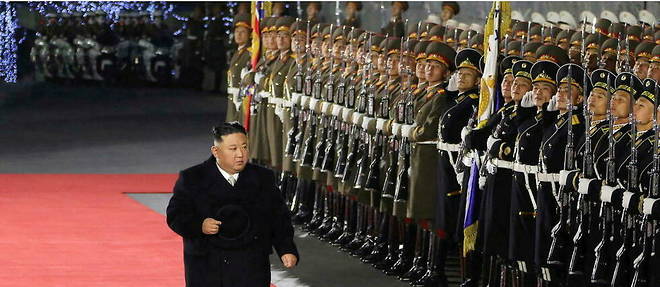 Kim Jong-un inspectant et saluant les rangs de soldats armes de baionnettes.
