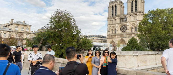 Des touristes devant la cathedrale Notre-Dame de Paris, en septembre 2022. 
