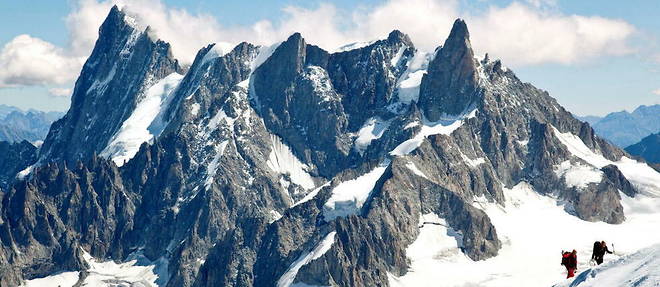 Deux alpinistes montent l'arete de la Vallee blanche, avec pour decor les Grandes Jorasses, la dent du Geant, et le glacier des Periades, vus depuis l'aiguille du Midi.
