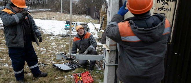 Des ouvriers de l'entreprise Oblenergo Energy s'affairent pour reparer le reseau electrique detruit par les Russes a Tsyrkuny, pres de Kharkiv.
