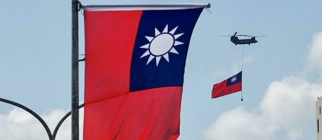 The flag of Taiwan is flying by a helicopter.
