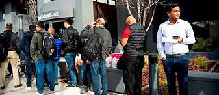  Des clients de la Silicon Valley Bank font la queue pour retirer leurs fonds au siège du groupe, à Santa Clara, en Californie, le 13 mars.  ©NOAH BERGER
