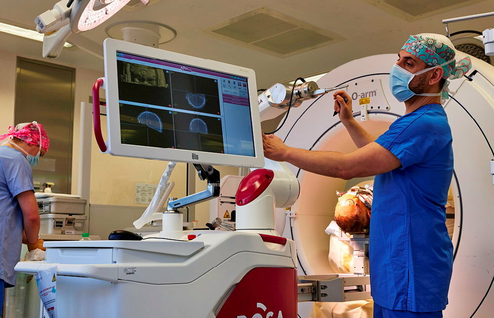 
        Interface. Le Pr Marco Corniola, chef du service de neurochirurgie au CHU de Rennes, pratique une intervention chirurgicale sur un patient souffrant de la maladie de Parkinson. A l'aide du robot, il implante des electrodes dans son cerveau.