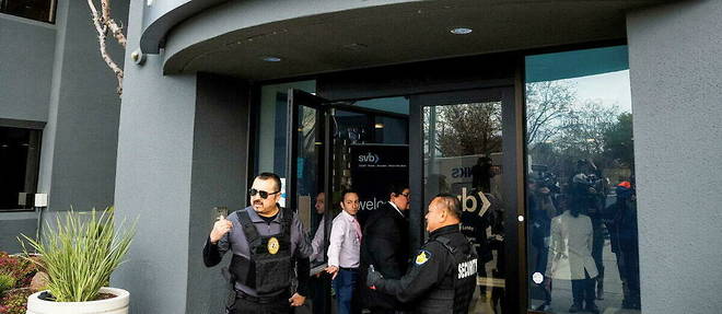 Des personnels de securite et des representants de la FDIC, l'agence federale de garantie des depots americains, devant la Silicon Valley Bank, a Santa Clara, en Californie, le 13 mars 2023.
