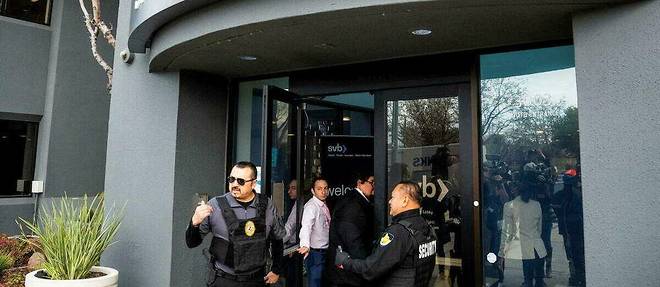 Des personnels de securite et des representants de la FDIC,               l'agence federale de garantie des depots americains,               devant la Silicon Valley Bank, a Santa Clara, en Californie, le 13 mars 2023.
