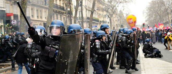 Des gendarmes face a des manifestants lors d'une journee nationale de greves et de protestations contre le projet de refonte des retraites, a Paris, le 11 mars 2023. 

