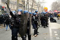 Des gendarmes face a des manifestants lors d'une journee nationale de greves et de protestations contre le projet de refonte des retraites, a Paris, le 11 mars 2023.

