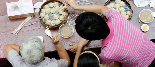 Des clients degustent des xiaolongbao, petits raviolis a la vapeur, a Shanghai en 2013. 