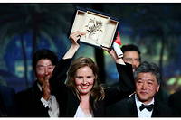 La realisatrice francaise Justine Triet, Palme d'or de Cannes 2023 avec  Anatomie d'une chute , sur scene entouree de l'acteur sud-coreen Song Kang-ho, du realisateur japonais Hirokazu Kore-eda et de l'acteur japonais Koji Yakusho.

