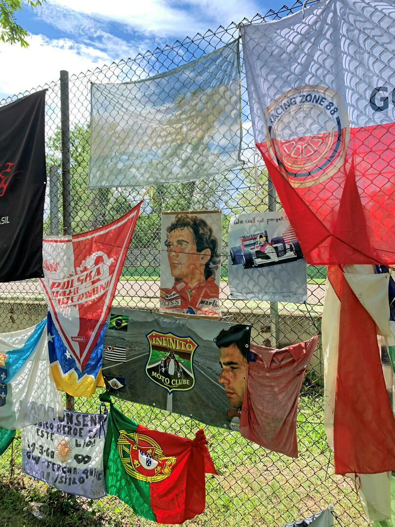 Les drapeaux, photos et souvenirs en mémoire du Brésilien, mais aussi du pilote autrichien Roland Ratzenberger, sont très nombreux, encore aujourd'hui, sur le circuit d'Imola. 
©  Jérémy Maccaud pour « Le Point »